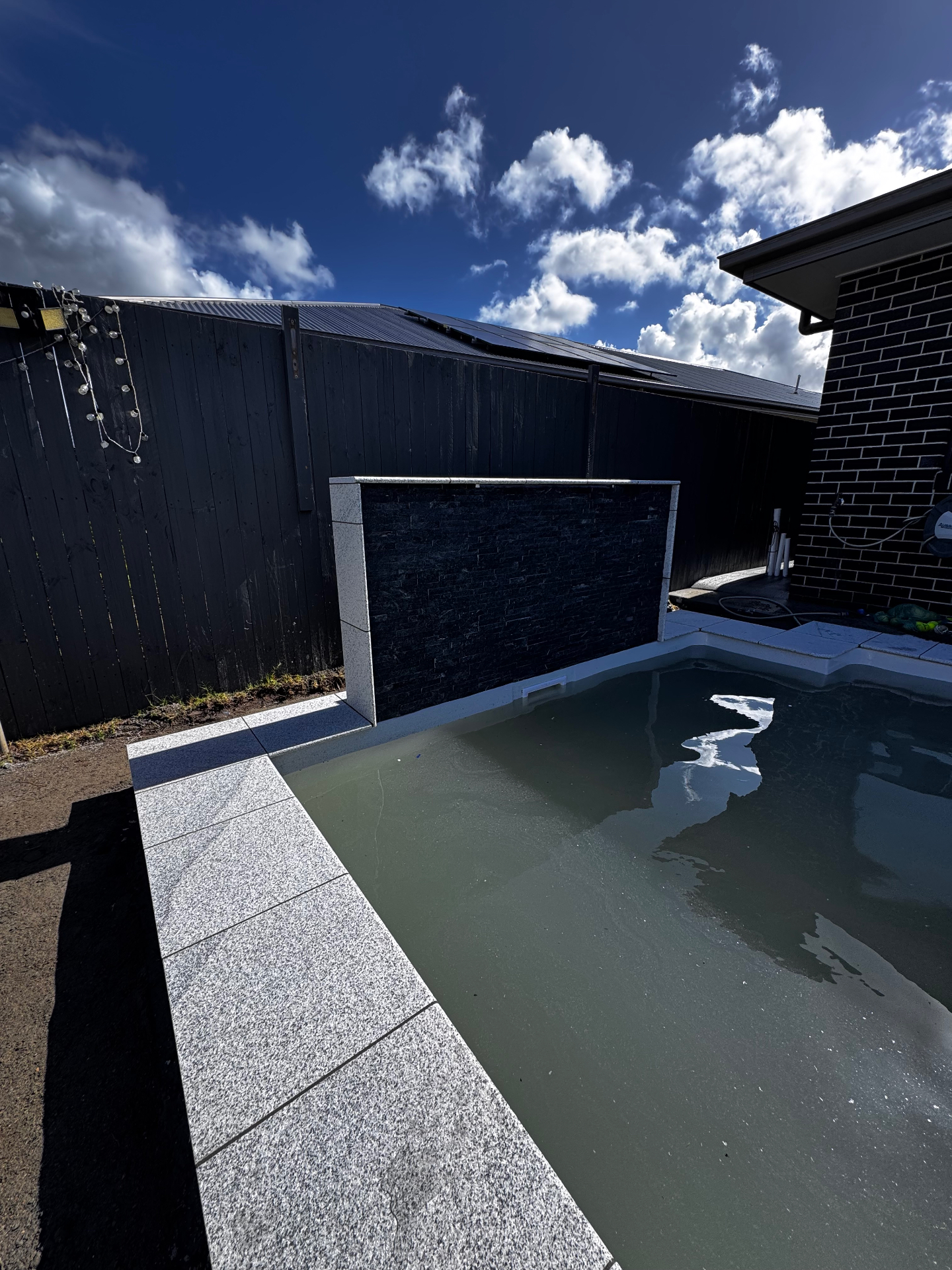 Pool with stacked stone feature wall — Brisbane